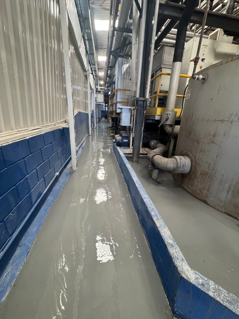 Piso Epóxi Industrial - Corredor com acabamento brilhante e maquinário
